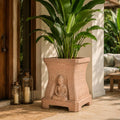 GoHooked sandstone square planter with a serene Buddha relief and engraved quotes, holding a large green plant.