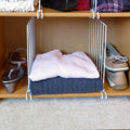 Go Hooked white wire shelf dividers organize folded sweaters, shoes, and sandals in a closet.