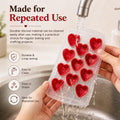 GoHooked red silicone heart-shaped chocolate mold being rinsed under a kitchen faucet for easy cleaning
