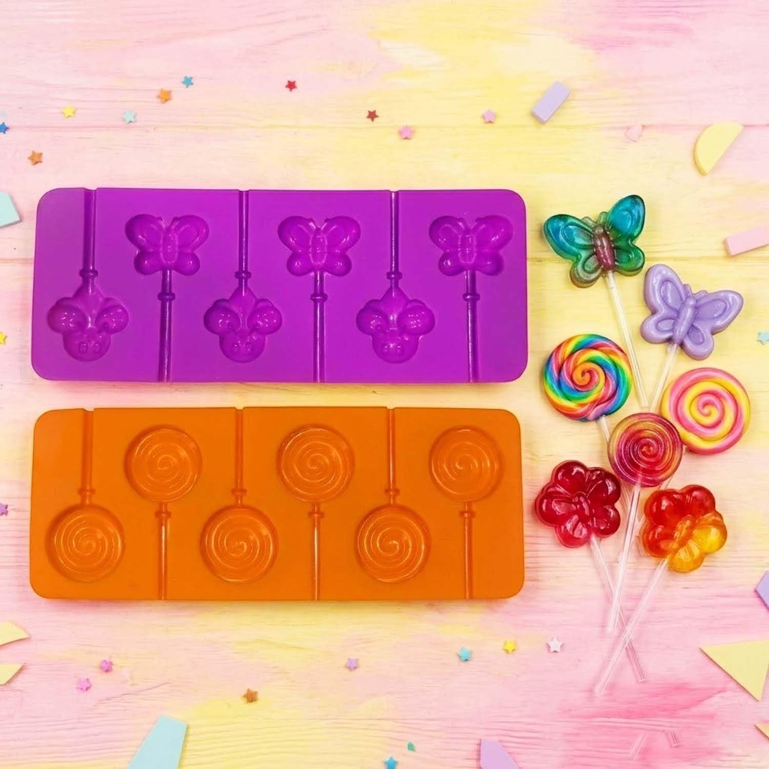 GoHooked silicone lollipop molds in purple and orange with butterfly and swirl shapes and finished candy treats.