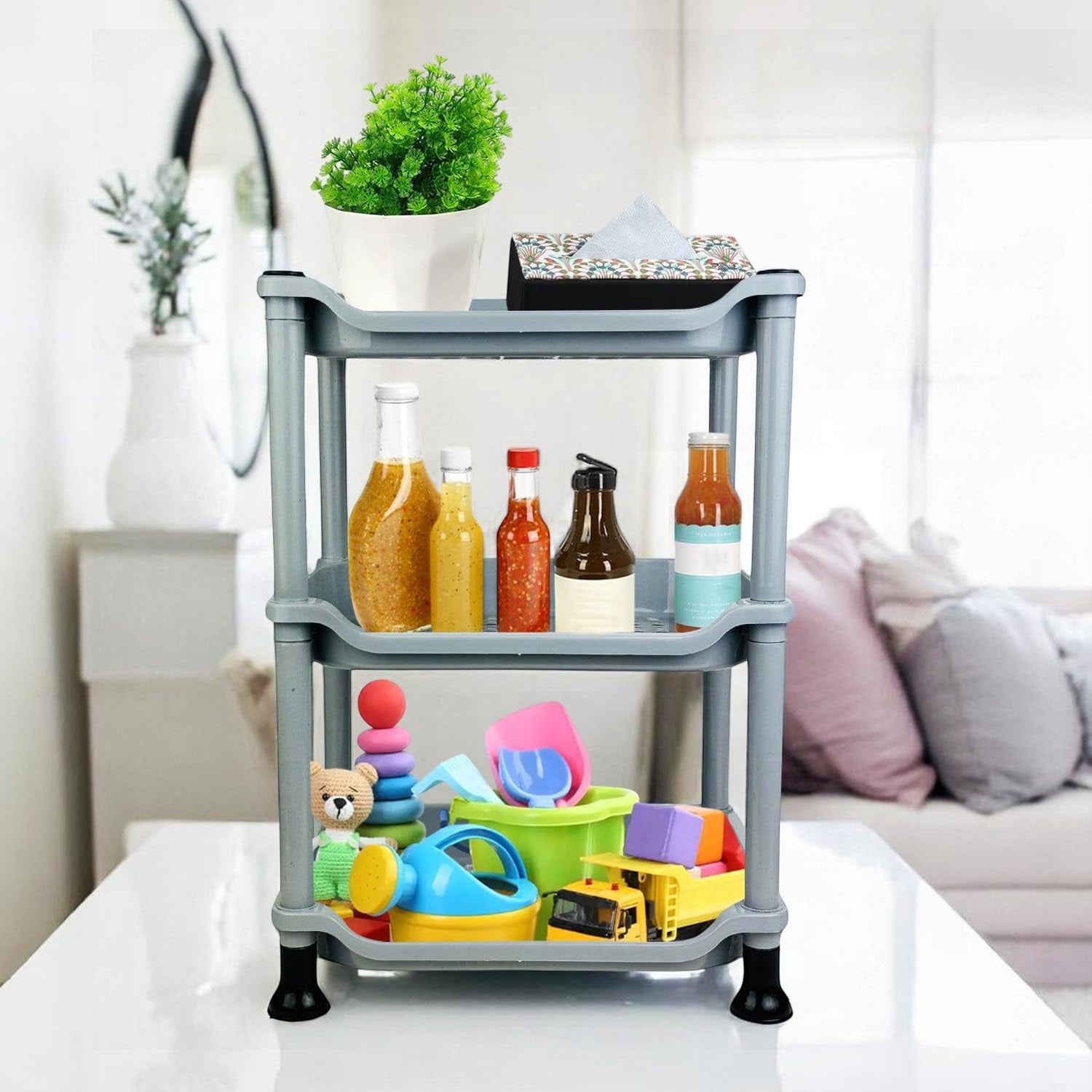 Go Hooked silver 3-tier plastic storage rack organizer filled with bottles, toys, and a plant.