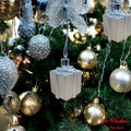 Go Hooked silver gift box Christmas ornaments with glitter accents, hanging on a decorated tree.