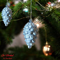 Go Hooked silver pine cone Christmas ornaments with glitter accents, hanging on a decorated tree.