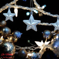 GoHooked silver glitter star Christmas ornaments hanging with festive lights and baubles.