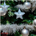 GoHooked silver star ornaments with glitter accents and silver baubles on a Christmas tree.