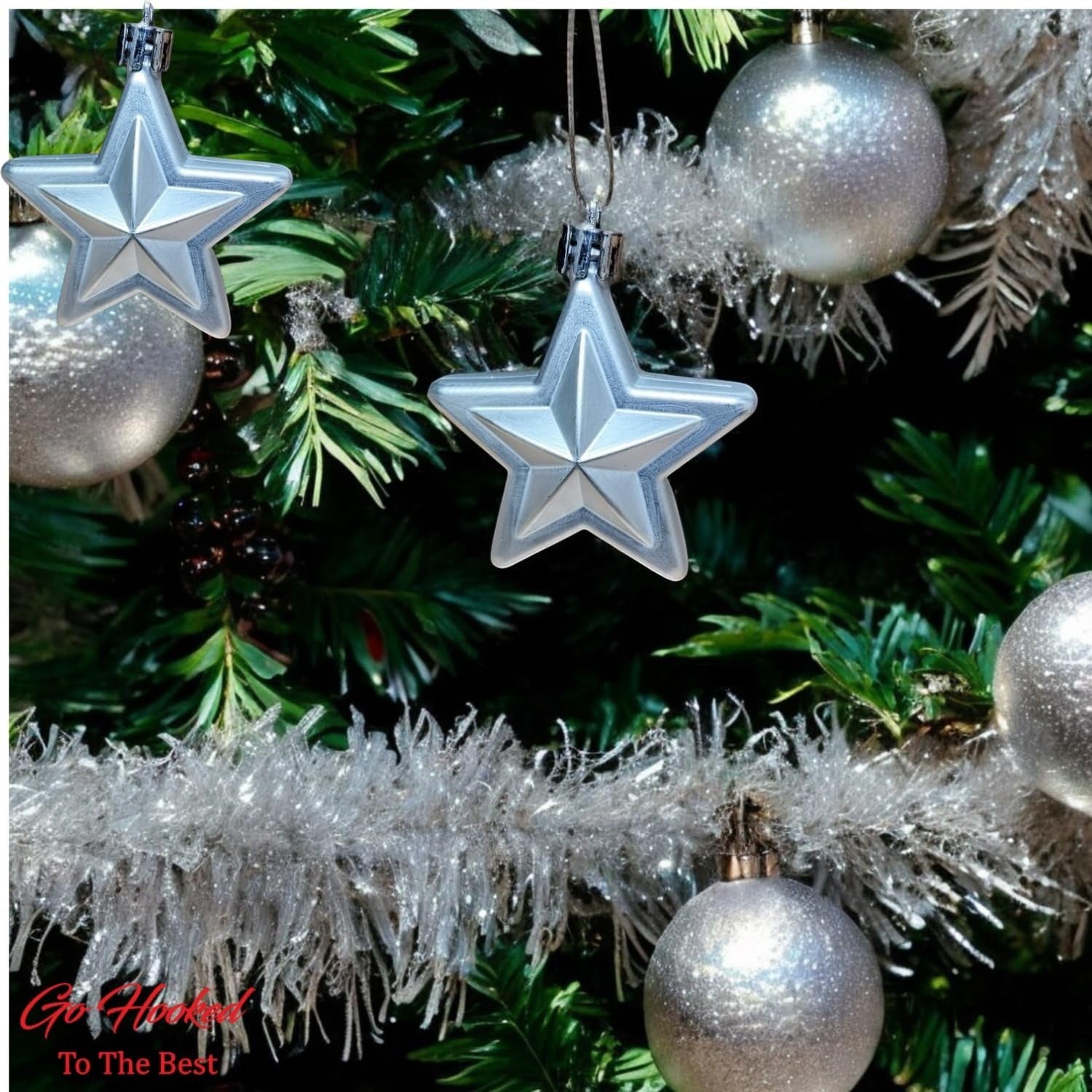 GoHooked silver star ornaments with glitter accents and silver baubles on a Christmas tree.