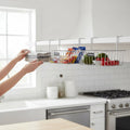 GoHooked silver wire under shelf basket with snacks, avocados, and tomatoes. Ideal for kitchen storage.