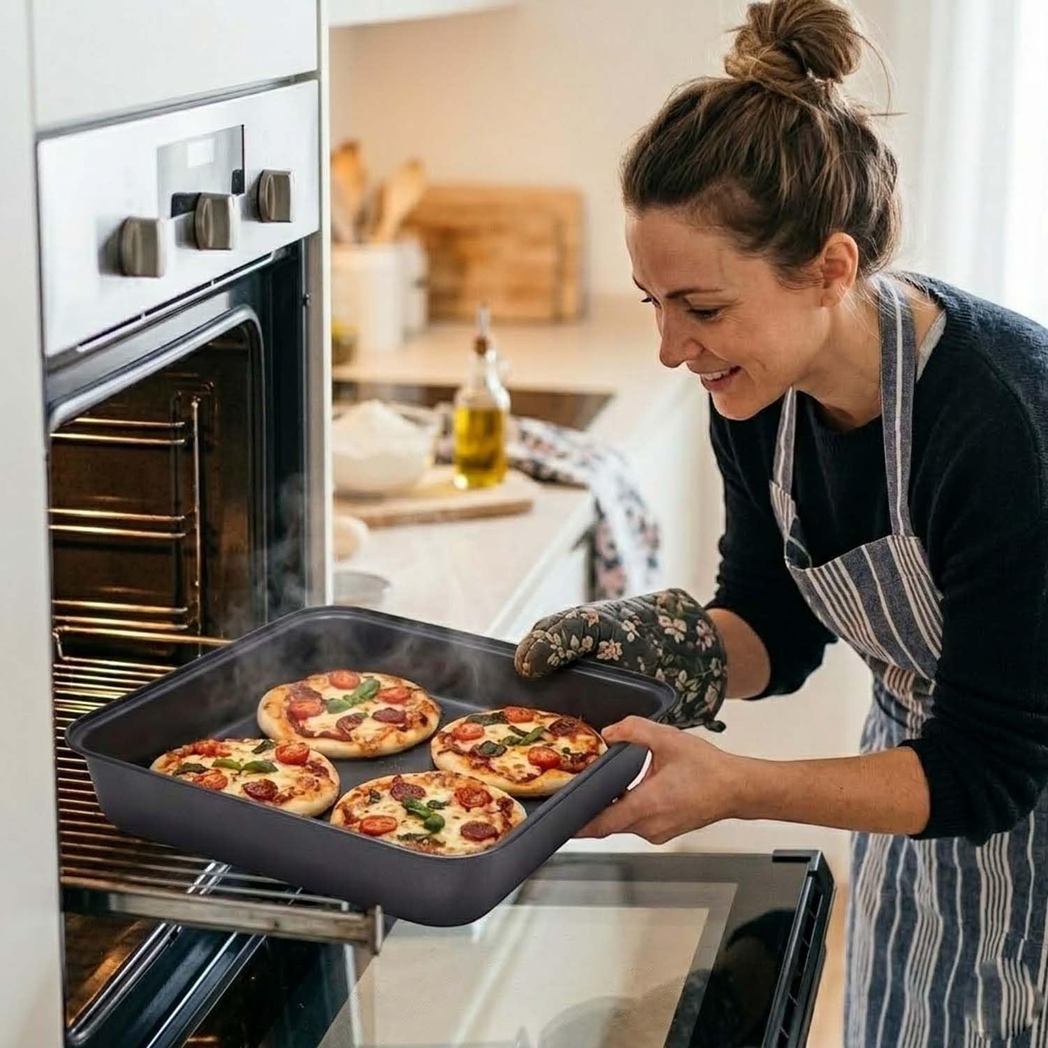 GoHooked grey square carbon steel baking pan with four mini pizzas, 23.5 x 22 x 5 cm.