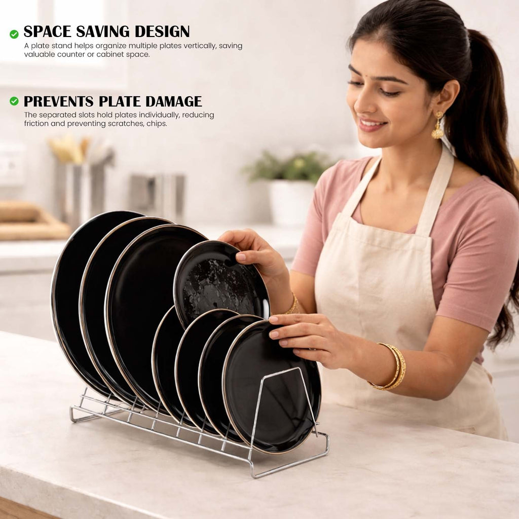 Woman placing black plates into a GoHooked stainless steel 6-section vertical dish rack on a kitchen countertop.