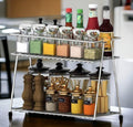 GoHooked stainless steel 2-tier shelf basket organizer filled with spices, condiments, and bottles.