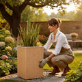 GoHooked tall brown polymer planter with ribbed texture, holding a snake plant in a garden setting.