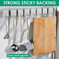 GoHooked transparent adhesive hooks holding kitchen utensils and a wooden cutting board. Heavy-duty, no-drilling required.
