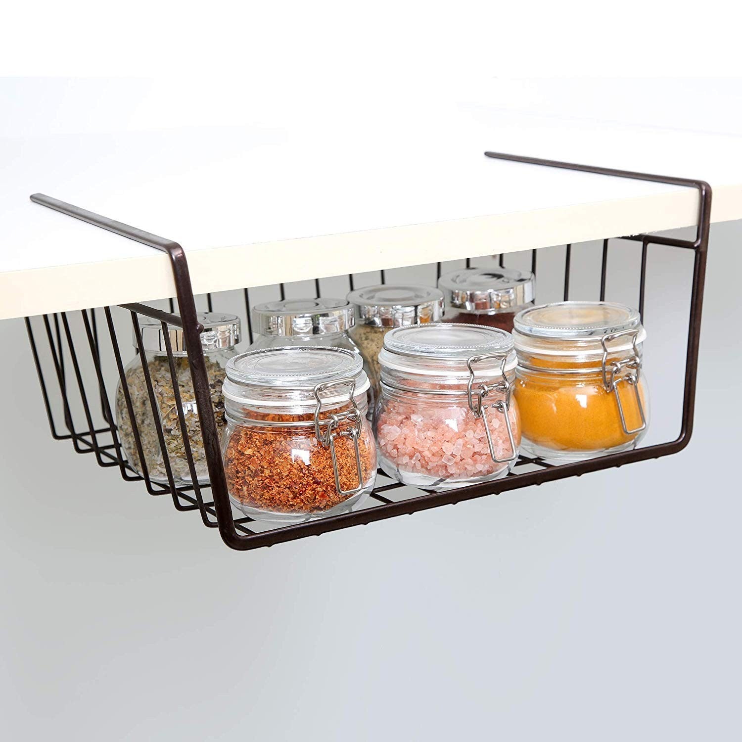 GoHooked black coated iron under shelf storage basket organizer rack holding glass jars of spices and seasonings.