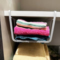 Go Hooked white metal undershelf basket holding folded colorful towels. Set of 2.