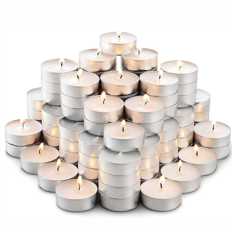 GoHooked pack of 150 unscented white tealight candles in silver holders, burning with a warm glow.