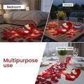 GoHooked Valentine's Day decor set with red heart-shaped tin box containing a teddy bear and roses, surrounded by red artificial rose petals and heart-shaped tea light candles.