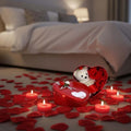 GoHooked Valentine's Day decor set with red heart tin box, teddy bear, artificial roses, 10 heart candles, and scattered rose petals.