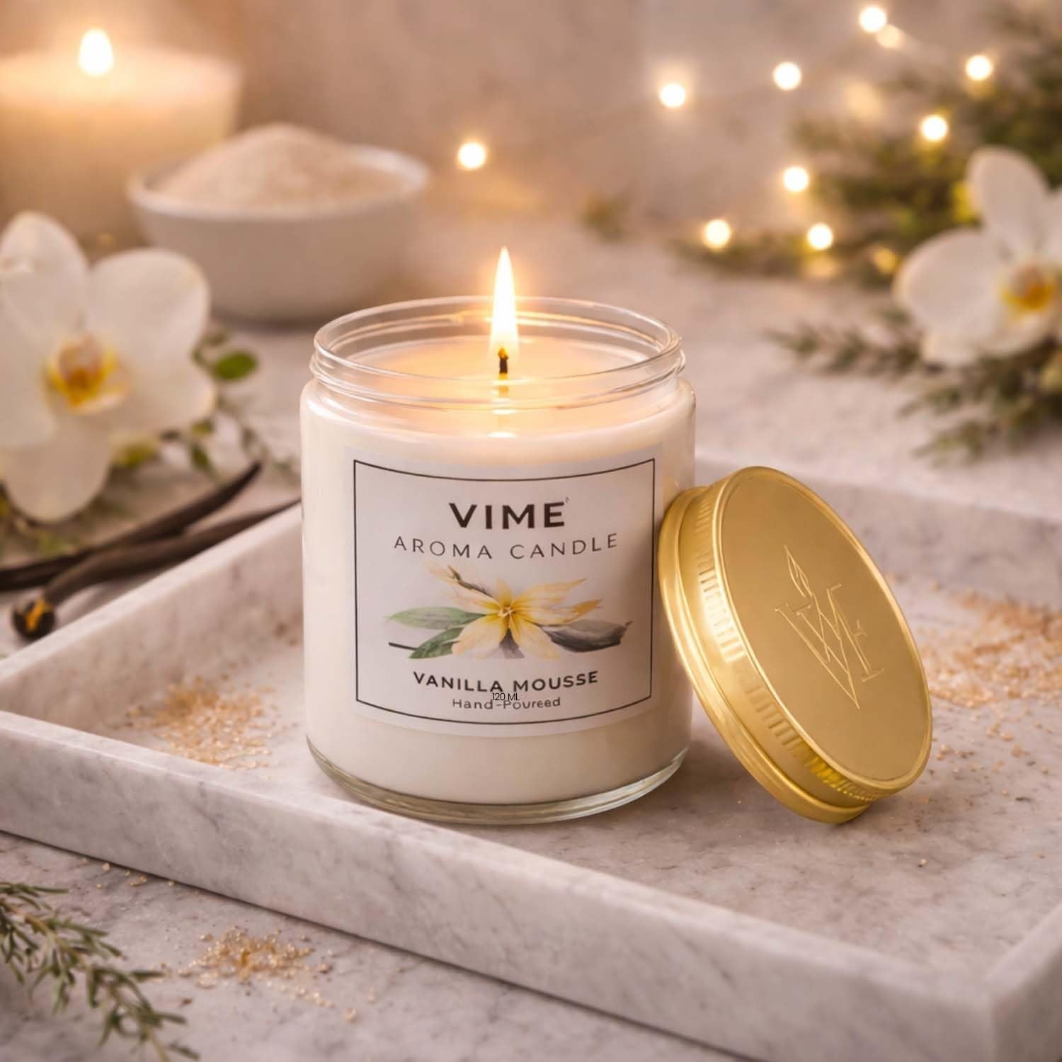 GoHooked ViMe Vanilla Mousse aroma candle in a glass jar with a gold lid, burning with a gentle flame.