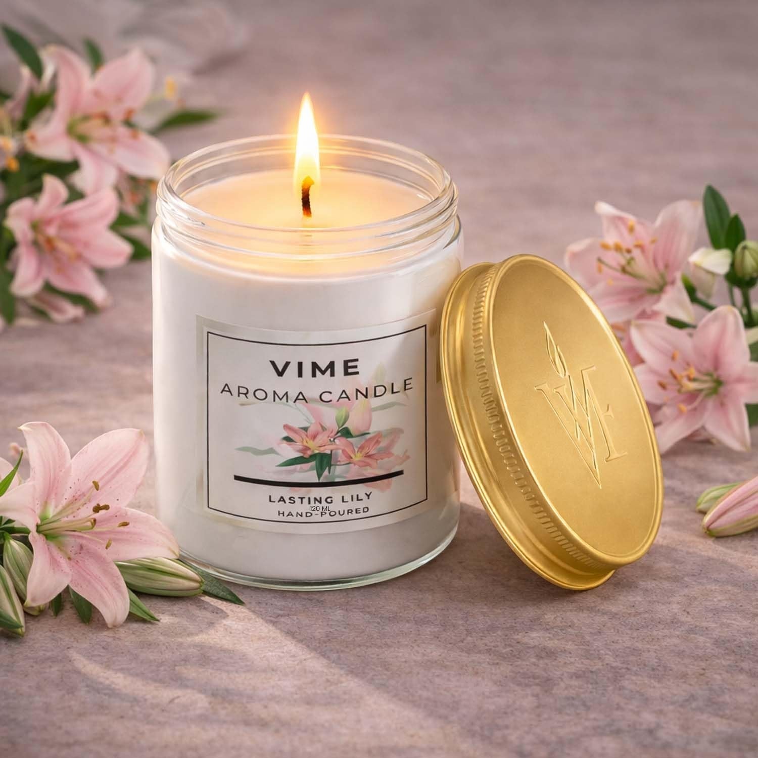 GoHooked ViMe white glass jar candle with a lit wick, featuring a jasmine scent and pink lilies. Hand-poured for home decor.