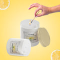 GoHooked ViMe Lemon Tart scented candle in a white jar, lit with a match. Aromatherapy candle.