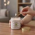 GoHooked ViMe white lemongrass scented aroma candle in a glass jar, being lit with a match.