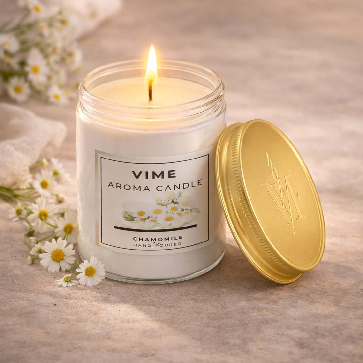 GoHooked ViMe white glass jar candle with gold lid, lit flame, chamomile scent, for home decor and aromatherapy.