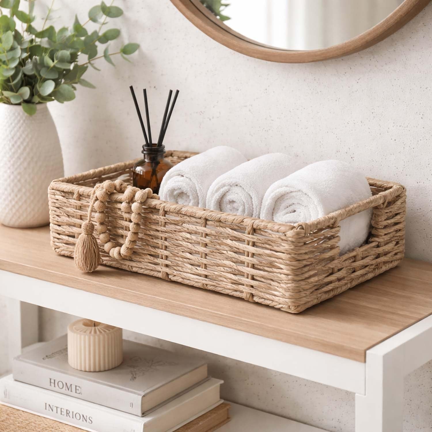 GoHooked handwoven rectangular water hyacinth storage basket with handles, filled with rolled white towels.