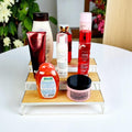 GoHooked white 3-tier iron countertop organizer rack with wood shelves holding various toiletries and body care products.