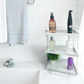 GoHooked white 3-tier iron countertop storage organizer with toiletries and a small plant.