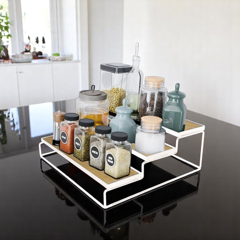 GoHooked white 3-tier iron countertop storage rack with wood-look shelves, holding spice jars and canisters.