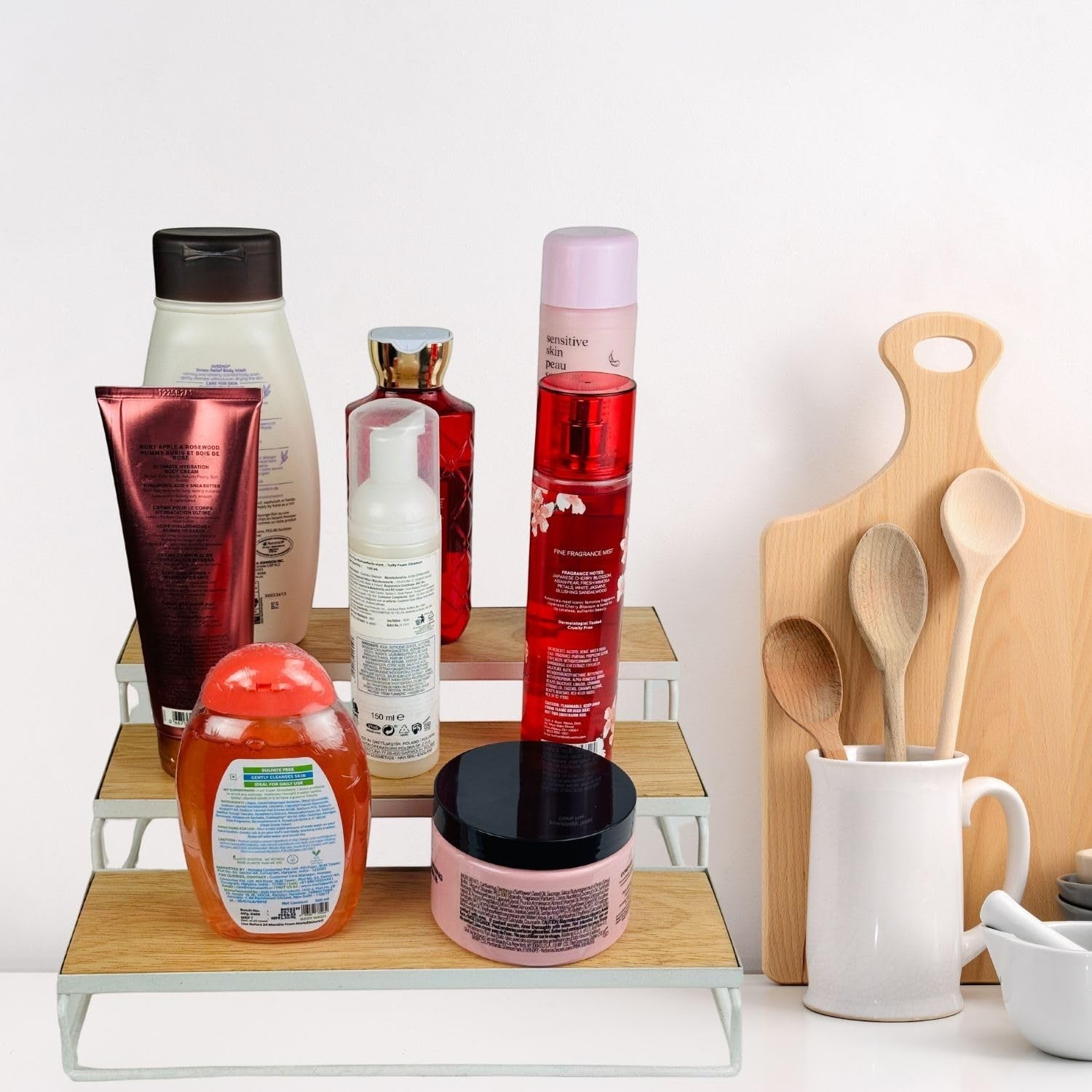 GoHooked white 3-tier wooden shelf organizer with metal frame, holding various bottles and jars of toiletries and cosmetics.