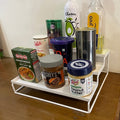 GoHooked white 3-tier metal step rack organizing spice jars, peanut butter, and cooking oil.