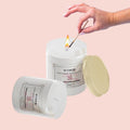 GoHooked white glass jar aroma candle with Serenity Bloom Lotus fragrance, lit by a match.
