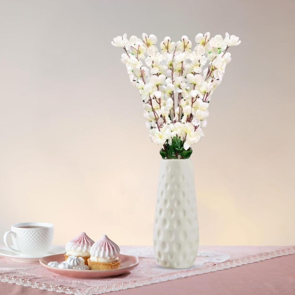 Go Hooked white artificial flowers in a textured white vase, a decorative accent for home or office.