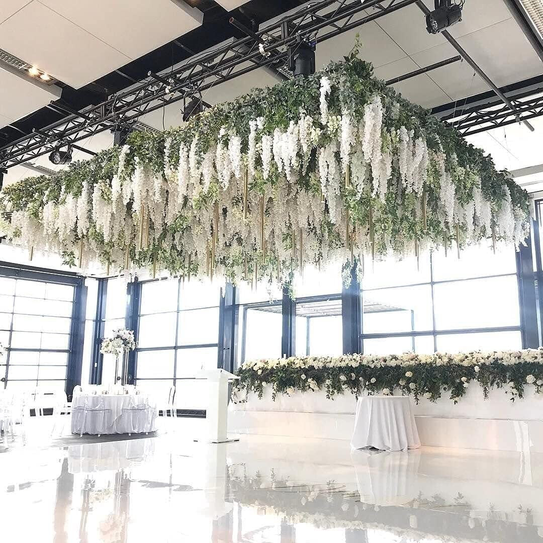 GoHooked white artificial wisteria silk flowers cascading from ceiling installation at wedding venue