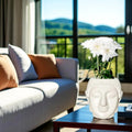 GoHooked white plastic Buddha head planter with white flowers, perfect for home decor.
