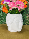 GoHooked white plastic Buddha head shaped planter with colorful flowers, perfect for home decor.