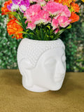 GoHooked white plastic Buddha head planter with colorful flowers. Ideal for home decor.