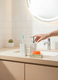 Go Hooked white ceramic 3-piece bathroom set with textured design, includes soap dispenser, toothbrush holder, and soap dish.