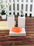 GoHooked white ceramic 3-piece bathroom set with textured pattern, includes soap dispenser, toothbrush holder, and soap dish with orange bar soap.