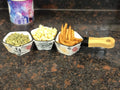 Go Hooked white ceramic snack serving tray with floral accents, holding pumpkin seeds, popcorn, and fries.