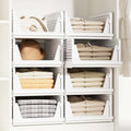 GoHooked white foldable plastic wardrobe organizers stacked in a cupboard with clothes, a hat, and a handbag.