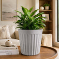 GoHooked white marble texture ribbed plastic planter pot holding a lush green plant on a wooden table in a living room