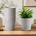GoHooked set of 7 white marble texture plastic planter pots with a modern ribbed design on a wooden table.