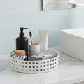 GoHooked white metal revolving bathroom organizer with grid pattern, holding toiletries and skincare.