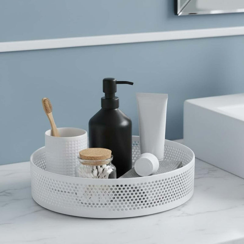 GoHooked white metal revolving bathroom organizer tray with perforated sides holding toiletries, skincare, and a toothbrush.