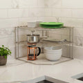 Go Hooked white metal 3-tier corner shelf organizer holding plates, bowls, a pot, and a French press.