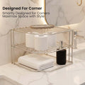 Go Hooked white metal 3-tier corner shelf organizer holding toilet paper, soap dispenser, and folded towel on a marble countertop.