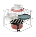 Go Hooked white metal 3-tier corner shelf organizer holding dishes, bowls, a cup, and a small pot.