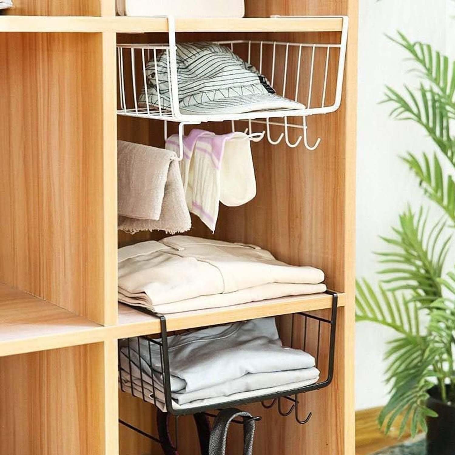 GoHooked white metal wire under shelf hanging basket organizer with hooks, holding folded clothes and a hat.